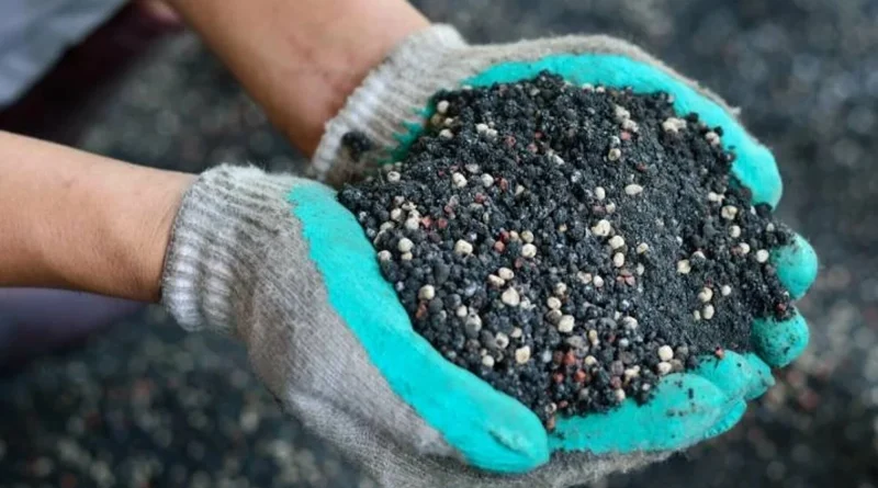 Gloved hands holding nutrient-rich soil with fertilizer granules